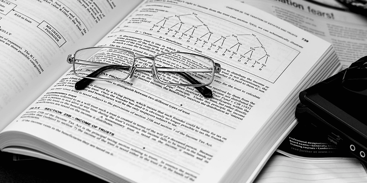 A pair of reading glasses and a camera rest on an open book, symbolizing the blend of literature and photography.