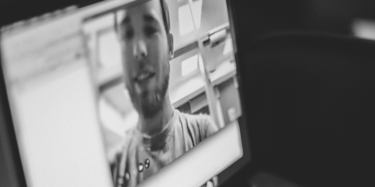 A computer screen displaying a man's face, highlighting a digital interaction or virtual meeting scenario.