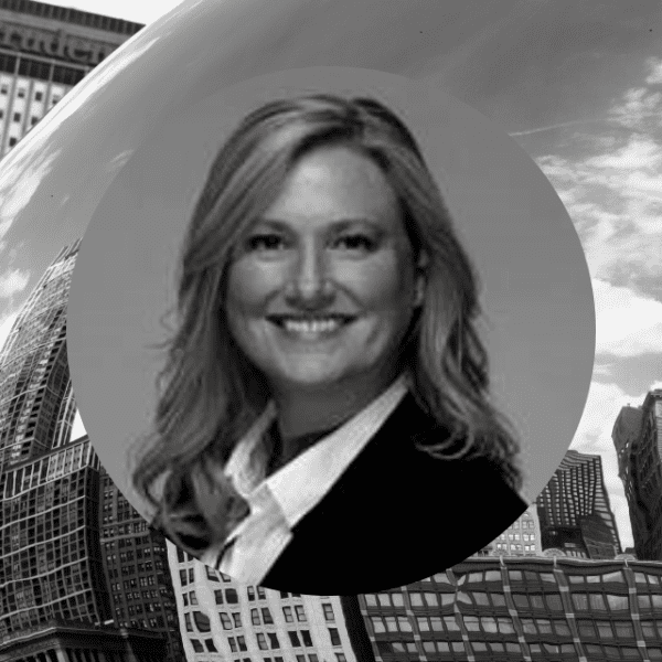A woman stands before a large, reflective bean sculpture, showcasing her admiration for the art piece.
